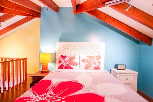 a bedroom with a bed with red flowers on it at The Villas at Cocoplum in Placencia Village
