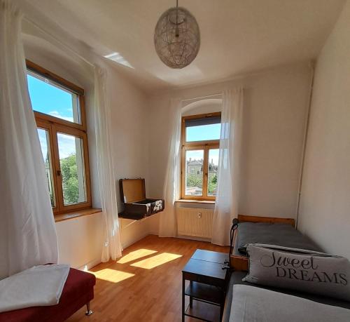 salon z kanapą i dwoma oknami w obiekcie Finka Monika w Dreźnie