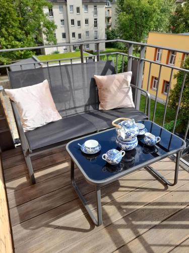 a blue coffee table on a balcony with a bench at Finka Monika in Dresden