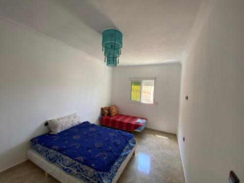 ein kleines Schlafzimmer mit einem Bett und einem Stuhl in der Unterkunft Sea house in Nador