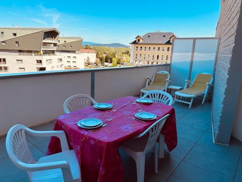 a table on a balcony with a table and chairs at A la belle quatrième étoile in Annecy