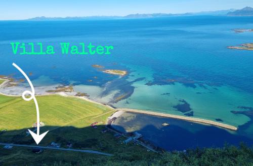 una vista aérea de un lago con una turbina eólica en Villa Walter Lofoten with jacuzzi, en Kvalnes