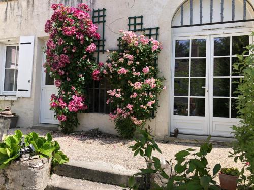 a house with flowers on the side of it at Les Troglos de la Tufolière in Rochecorbon