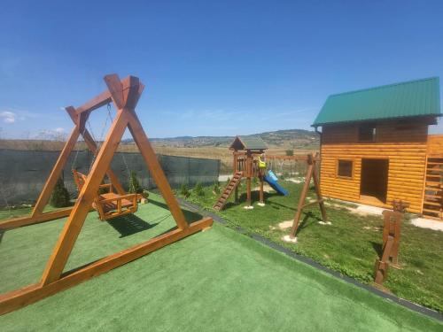 un patio con parque infantil y una cabaña de madera en Vikendica-chalet-Nišici, en Ilijaš