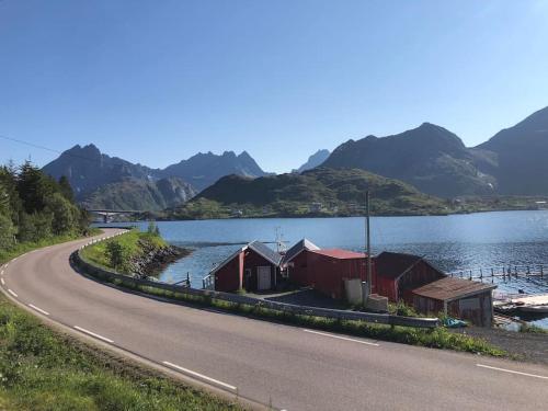 a road next to a body of water with mountains at Mørkveden feriehus, Lofoten in Ramberg