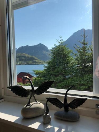 two birds statues sitting on a window sill at Mørkveden feriehus, Lofoten in Ramberg