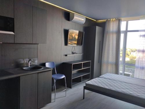 1 dormitorio con cama, lavabo y escritorio en Номер-студіо "Міні Феофанія" Заболотного 148, Кришталеві Джерела, лікарня, пораненим воїнам -10", en Kiev