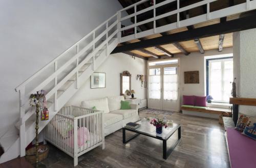 a living room with a white couch and stairs at To Spitaki Apartments in Galaxidhion