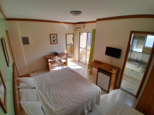 a bedroom with a bed and a television and a bathroom at Golden Dolphin Resort - Caldas Novas - GO in Caldas Novas