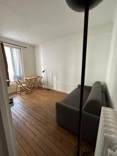 een woonkamer met een bank en een tafel bij Studio idéal proche centre Paris in Boulogne-Billancourt