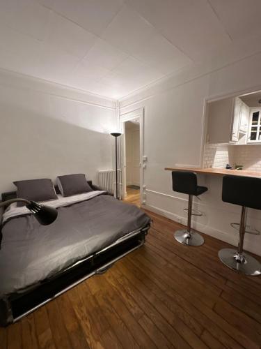 een slaapkamer met een bed en een bureau. bij Studio idéal proche centre Paris in Boulogne-Billancourt
