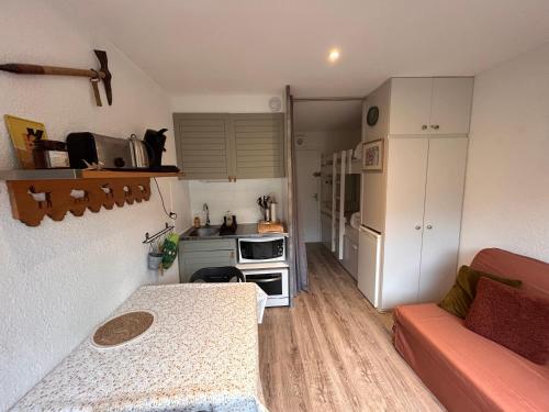 un petit salon avec un canapé et une cuisine dans l'établissement Appartement cosy avec balcon, à Puyvalador