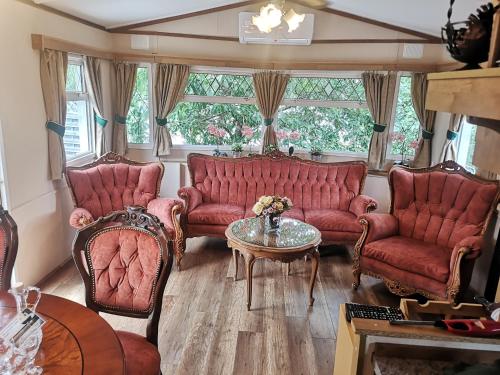 a living room with red couches and a table at Agroturystyka u Kozdryka in Leśna