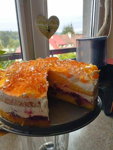a piece of cake sitting on a plate next to a window at Agroturystyka u Kozdryka in Leśna