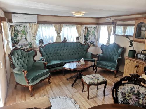 a living room with two green couches and a table at Agroturystyka u Kozdryka in Leśna