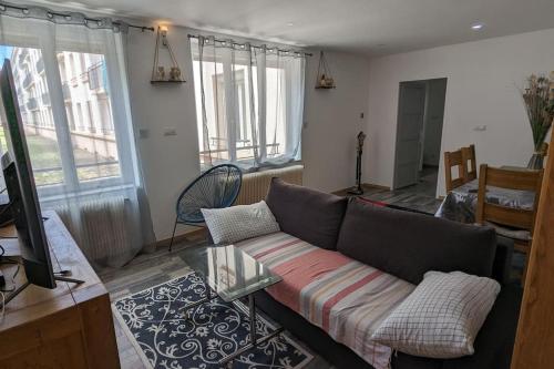 ein Wohnzimmer mit einem Sofa und einem Tisch in der Unterkunft calme rez-de-chaussée 2 Chambres 70 M2 in Roanne