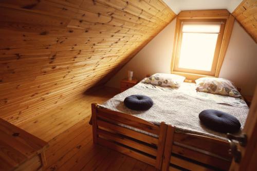 ein Schlafzimmer mit einem Bett mit zwei Kissen darauf in der Unterkunft Domek na Kamieńcu in Wilkowice