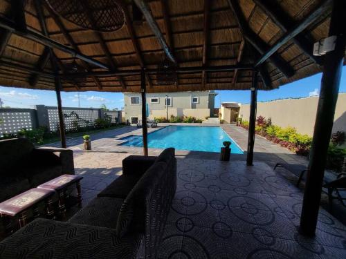 an outdoor patio with a swimming pool and a pavilion at Casabella-macaneta in Praia de Macaneta