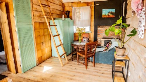 Zimmer mit einer Leiter, einem Tisch und einem Stuhl in der Unterkunft Stokrotka in Glaznoty