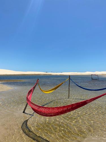 a hammock in the water on a beach at Kitesurf Life Arpoador da Tutoia in Tutóia