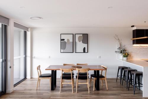 a dining room with a wooden table and chairs at Little Island Apartments in Hobart