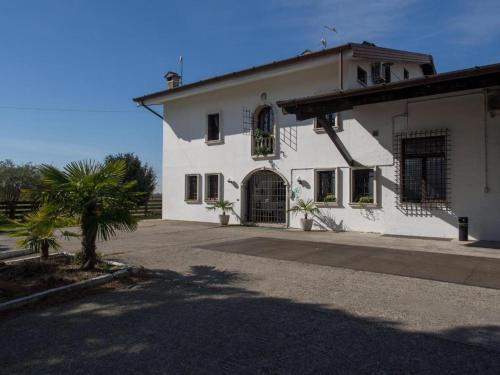 a white house with a palm tree in front of it at Tenuta PARAVANO in Savorgnano