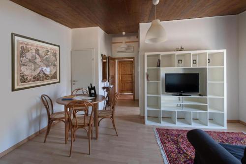 uma sala de estar com uma mesa de jantar e uma televisão em Tenuta PARAVANO em Savorgnano