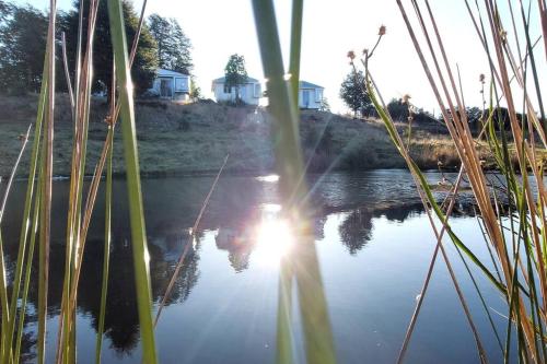 a reflection of the sun in a body of water at Cabaña Carpintero negro in Dalcahue
