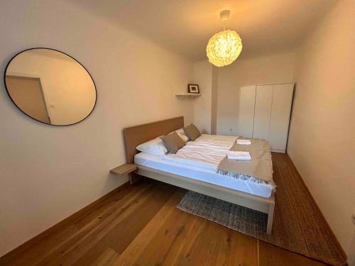 1 dormitorio con cama y espejo grande en Urbaner Charme: Stilvolles Wohnen im Herzen Wiens en Viena