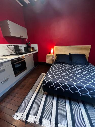 a bedroom with a bed and a red wall at 101 Studio en plein cœur historique de Bourges in Bourges