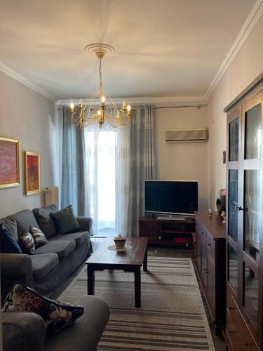 a living room with a couch and a tv at Authentic Greek Charming Central in Patra