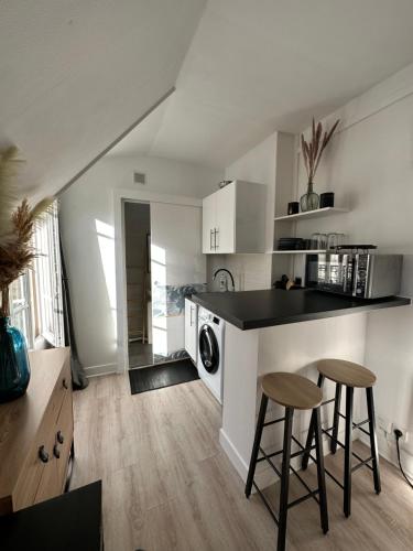 une cuisine avec un comptoir et deux tabourets de bar dans l'établissement TiParis, à Paris