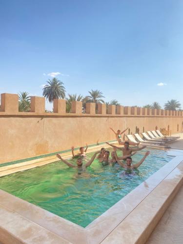 um grupo de pessoas numa piscina em Desert Villa Boutique Hotel Merzouga em Merzouga