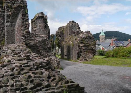 an old stone wall with a building in the background at Abergavenny Center 2-Bed Flat in Abergavenny