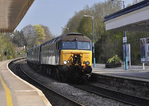 a yellow train on the tracks at a train station at Abergavenny Center 2-Bed Flat in Abergavenny