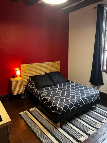 a bedroom with a bed and a red wall at 101 Studio en plein cœur historique de Bourges in Bourges