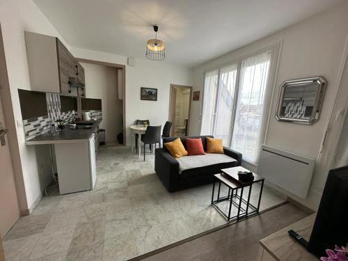 un soggiorno con divano e una cucina di Spacious flat close to the railway station a Troyes