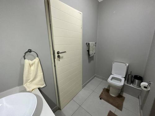 een witte badkamer met een toilet en een wastafel bij Maria’s Place in Midrand