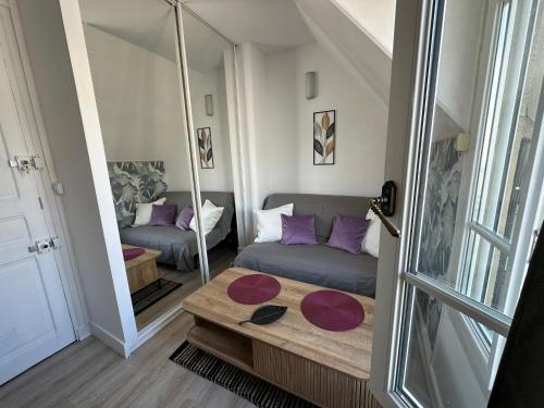 un salon avec un canapé et un miroir dans l'établissement TiParis, à Paris