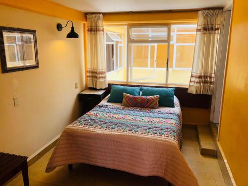 - une chambre avec un grand lit et une fenêtre dans l'établissement Belisana, à Ixtapan de la Sal