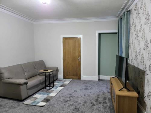 ein Wohnzimmer mit einem Sofa und einem Flachbild-TV in der Unterkunft 16 Northcote Street, Wick in Wick