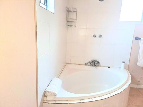 a bathroom with a bath tub in a room at Residential Inn in Pretoria