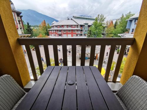 een houten tafel op een balkon met uitzicht bij Bear Lodge One Bedroom by MVA in Whistler