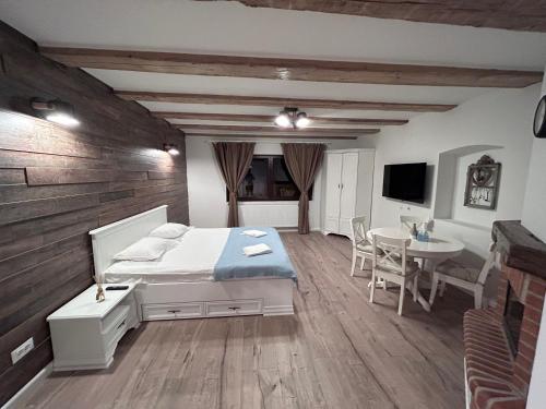 Schlafzimmer mit einem Bett, einem Tisch und einem TV in der Unterkunft Studio Alexandra in Săcele