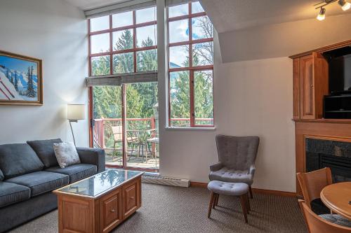a living room with a couch and a chair at Alpenglow Lodge One Bedroom Penthouse by MVA in Whistler