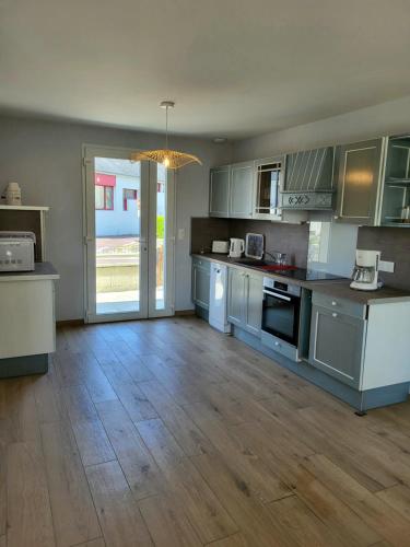 a kitchen with blue cabinets and a wooden floor at Gîte Cadet rousselle in Lessay