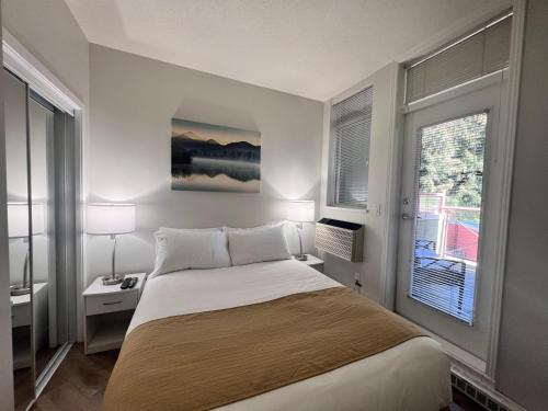 a bedroom with a large bed and a window at Alpenglow Lodge West Coast Wonder by MVA in Whistler