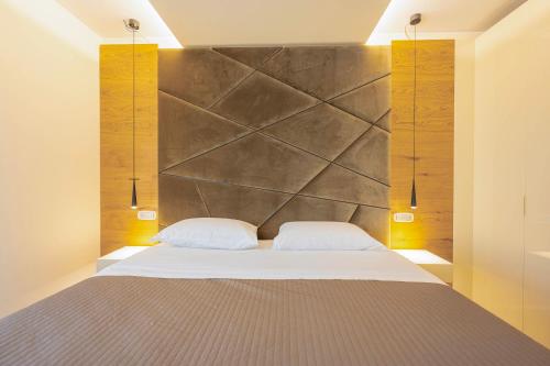 1 dormitorio con 1 cama grande y 2 almohadas blancas en Venice New Luxury Penthouse - free parking and roof terrace, en Mestre