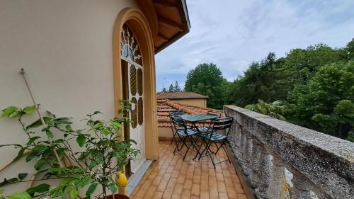 a balcony with a table and chairs on a wall at Villa Tessa in Ronciglione