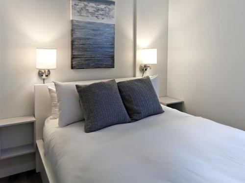 a bedroom with a white bed with two pillows at Alpenglow Lodge HYGGE Getaway by MVA in Whistler